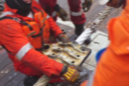 Marine crew doing anchor handling activities with motion blur effect.