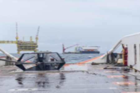 Marine crew ready to release anchor on deck during anchor handling activities in monsoon season with...
