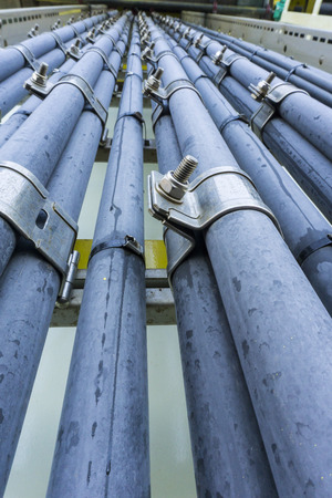 Low angle view of high voltage electrical cables with chrome clamp for heavy industries use. Selective focus.の写真素材
