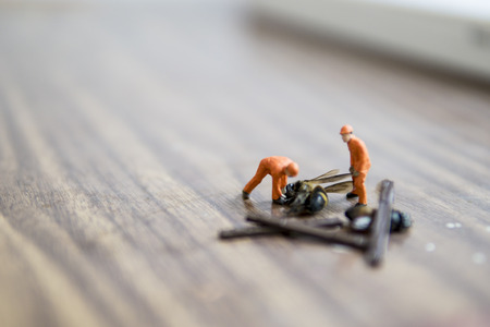 Miniature figure accident in workplace - Close up of construction workers try to lift up dead hornet accident concept with selective focus.の写真素材