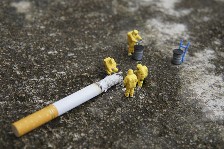 Miniature figures working in industrial - Close up of Hazardous Material (HAZMAT) teamwork concept with half cigarette on the floor.の写真素材