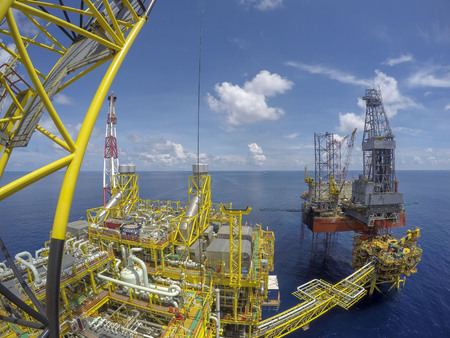 Oil and gas industry. Aerial view of oil and gas platform with jack-up rig in the middle of the sea with blue sky.の写真素材