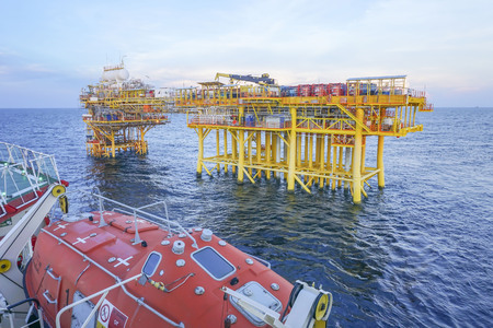 Oil and gas industry. View of commercial diving vessel nearby oil and gas drilling platform in open sea.の写真素材