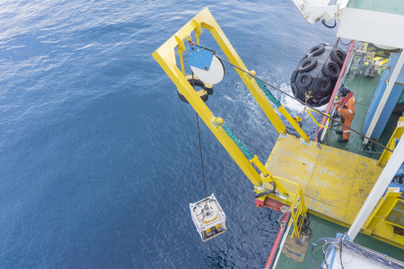 Offshore worker standing on Remote Operated Vehicle (ROV) platform deploy ROV to the open sea.の写真素材