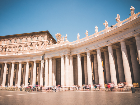 St. Peters square in the Vatican City within Rome, Italy during a sunny day in June. You see tourists lining up by the colonnades to get into the Basilica.のeditorial素材