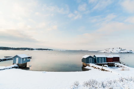 A beach south of Gothenburg, Sweden Scandinavia is covered in snow after heavy snowfall in December. You see little houses that are used in the summer to change clothes. Location: T Jetty T-bryggan in Hovas, Gothenburg.の写真素材