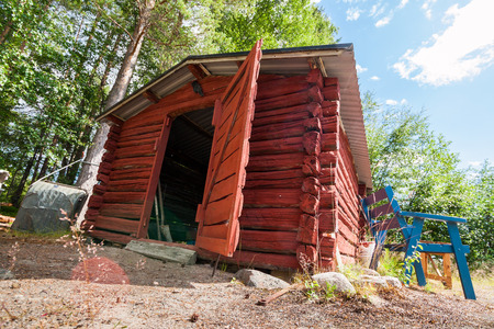 An old vintage typical Swedish toolshed in the Scandinavian woods. Dutch angle.の写真素材