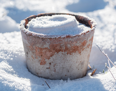 A flowerpot made out of earthenware is filled with snow and frost in the winter. Location: Sweden.の写真素材
