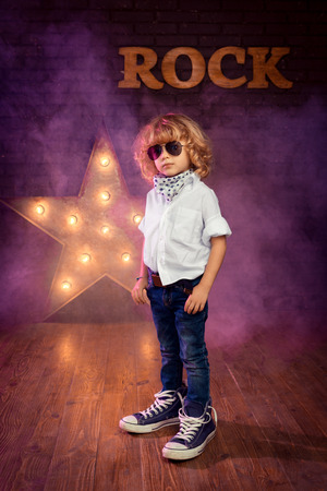 Little Boy Rock Star On Brick Wall Backgroundの写真素材