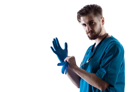 Man Doctor Surgeon Putting On Nitrile Gloves Isolated On White Backgroundの写真素材