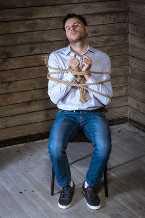 Tied With A Rope Man Sitting On A Chairの写真素材