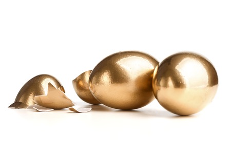 Two Golden Eggs Near The Broken Egg Isolated On White Background