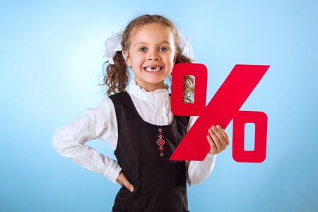Little Girl Without Teeth Holding A Percent Sign Isolated On Blue Backgroundの写真素材