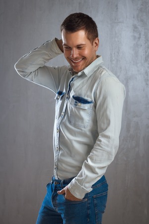 Portrait Of Handsome Stylish Young Man In A Shirt On Grey Backgroundの写真素材