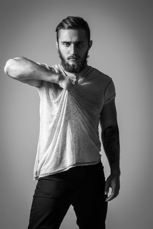 Handsome Bearded Man With Tattoo In Grey T-shirt Posing On Background. Model Testsの写真素材