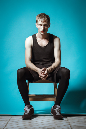 Handsome Man In Black Shorts And T-shirt Posing On Blue Background. Model Testsの写真素材