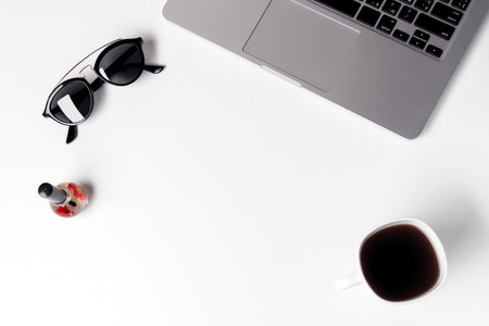 Cup With Coffe, Sunglasses And Nail Polish Near Laptopの写真素材