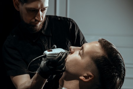 YOUNG HANDSOME MAN IN BARBERSHOPの写真素材