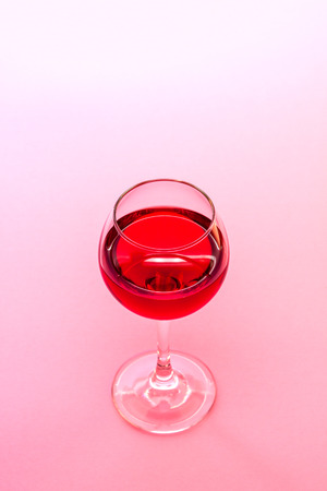 A Glass Of Red Wine On Pink Backgroundの写真素材