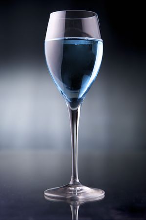 Wineglass with blue liquid on black backgroundの写真素材