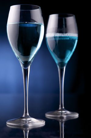 Wineglass with blue liquid on black backgroundの写真素材