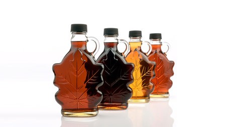 Bottles of maple syrup grades isolated on white background. studio shot.の素材