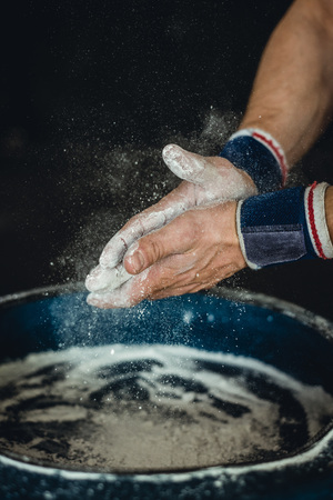 Chalking hands to prepare for weightlifting.の写真素材