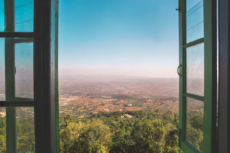 A green window opens up over the beautiful landscape of Pindaya in the country of Myanmar, Burma. This day there were many fires and the pollution was visible on the horizon.の写真素材