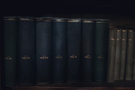 A row of old books lined up on the bookshelf.