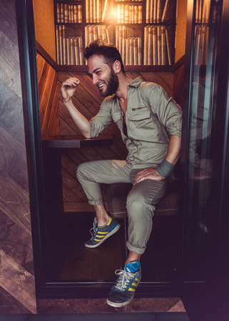 Handsome man in mid thirties wearing a khaki one piece jumpsuit posing.の写真素材