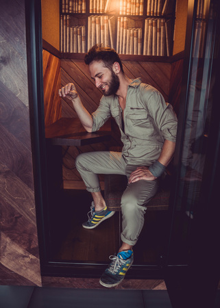 Handsome man in mid thirties wearing a khaki one piece jumpsuit posing.の写真素材