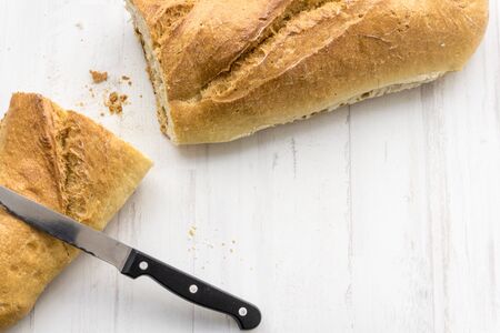 Loaf of bread cut in half and knifeの写真素材