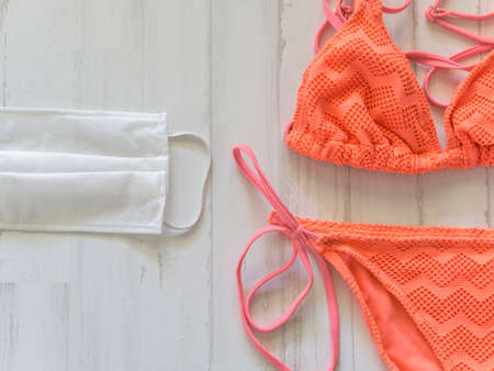 orange bikini and surgical mask to protect yourself in the pool or beach on vacation