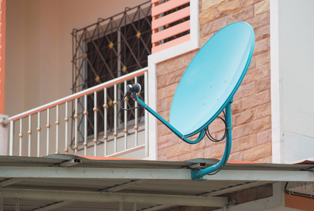 Green satellite dish on the roofの写真素材