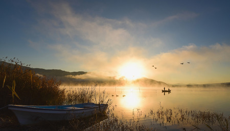 Sunrise at the lake Kawaguchiko,People fishing on a boat,silhouetteの写真素材