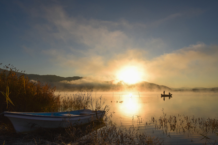 Sunrise at the lake Kawaguchiko,People fishing on a boat,silhouetteの写真素材