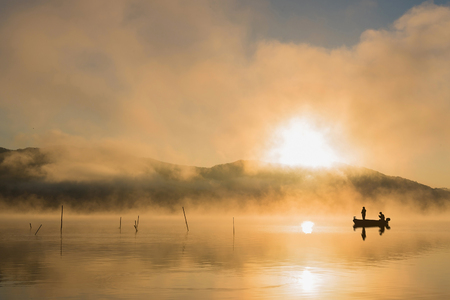 Sunrise at the lake Kawaguchiko,People fishing on a boat,silhouetteの写真素材