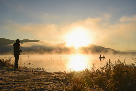 Sunrise at the lake Kawaguchiko,People fishing on a boat,silhouetteの写真素材
