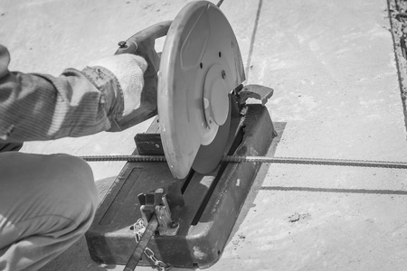 cutting a metal and steel with compound mitre saw with sharp, circular blade , black and whiteの写真素材