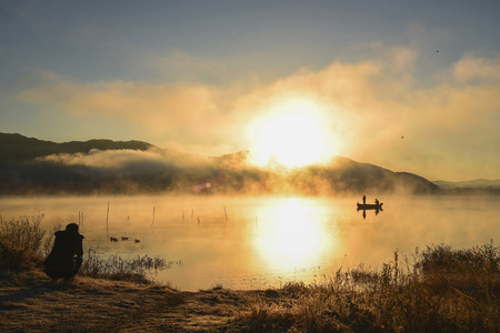 Sunrise at the lake Kawaguchiko,People fishing on a boat,silhouetteの写真素材