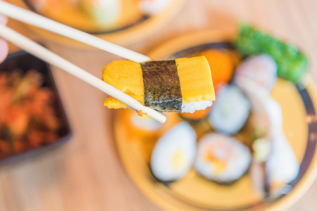 picking up a piece of sushi with chopsticksの写真素材