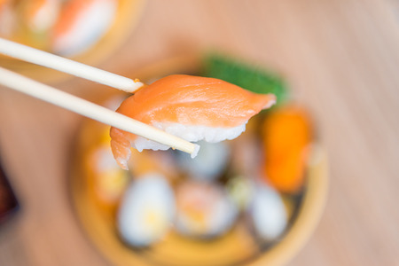 picking up a piece of sushi with chopsticksの写真素材