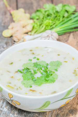 Traditiona porridge rice gruel in bowl on wooden backgroundの写真素材