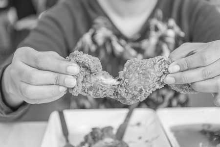 Hand holding Fried chicken and eating in the restaurant , black and whiteの写真素材