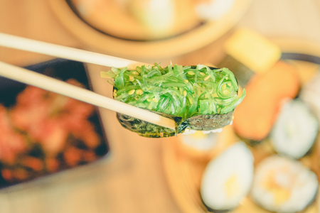 picking up a piece of sushi with chopsticks ,vintageの写真素材