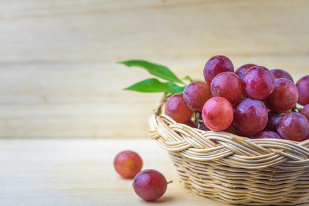 purple round grapes on old wooden tableの写真素材