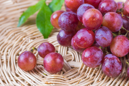 purple round grapes on  wicker basketsの写真素材