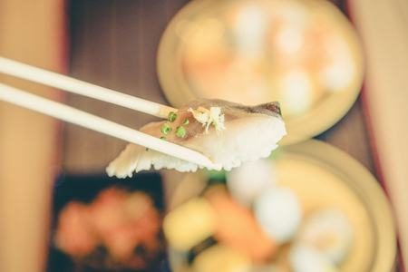 picking up a piece of sushi with chopsticks ,vintageの写真素材