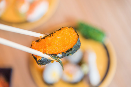 picking up a piece of sushi with chopsticksの写真素材