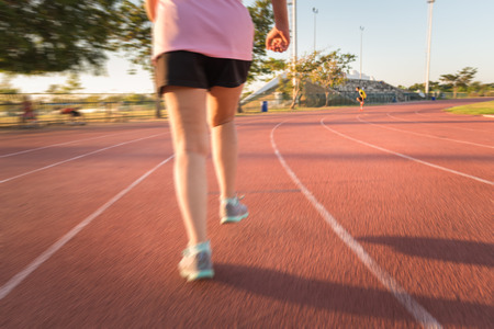 blur young fitness woman running , sunset